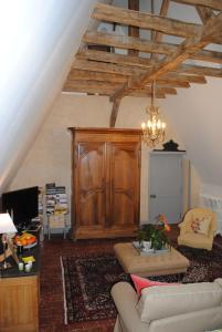 ein Wohnzimmer mit einem Sofa und einem Holzschrank in der Unterkunft Suite dans un château dans le Haut Anjou in Pouancé