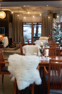 a dining room with a christmas tree and a table and chairs at Hotel Promyk Wellness & Spa in Karpacz