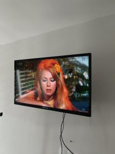 a flat screen tv with a woman with red hair at AniBo Studios & Apartments center 3861 in Thessaloniki