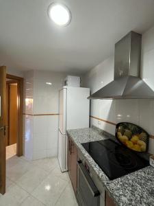 a kitchen with a refrigerator and a bowl of fruit on the counter at Toto&Koko apartment in Denia +12 photos