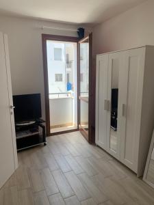 an empty living room with a door and a television at Holidays Apartment in Cagliari