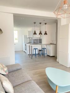 ein Wohnzimmer und eine Küche mit einer Couch und einem Tisch in der Unterkunft L'Ajax Appartement T3 centre et Bord de mer in Ajaccio