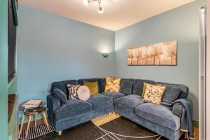 a living room with a blue couch with pillows at 4-br Free Parking Fast Wi-fi Workstation in Norwich