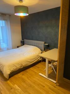 um quarto com uma cama e uma mesa em Sérénité totale : appartement ensoleillé em Clichy