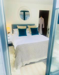 a bedroom with a large white bed with blue pillows at Cabin by the coast in Edinburgh