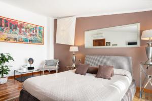 a bedroom with a bed and a mirror on the wall at Relais La Lanterne in Cagliari