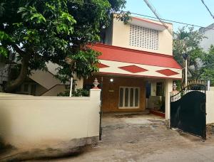 uma casa com um telhado vermelho e branco em HOMESTAY - AC 5 BHK NEAR AlRPORT em Chennai