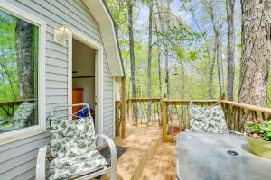 a porch with two chairs and a table at Inviting Des Arc Cabin with Fire Pit and Deck! in Des Arc