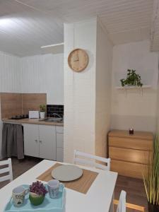 cocina con mesa y reloj en la pared en Chez Nous en Cherbourg en Cotentin