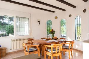 een eetkamer met een houten tafel en stoelen bij La Paz in El Tosalet