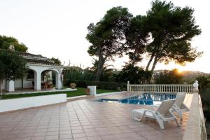 een huis met een zwembad en twee witte stoelen bij La Paz in El Tosalet