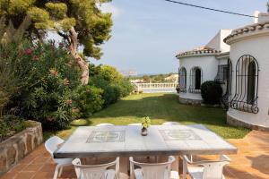 een terras met een tafel en stoelen in een tuin bij La Paz in El Tosalet