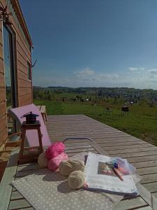 una mesa de picnic en una terraza con un libro y bolígrafos en Maringotka_naluke, en Detvianska Huta