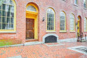 セーラムにあるChic Derby Square Condo in the Heart of Salem!の黄色のドアと窓のあるレンガ造りの建物