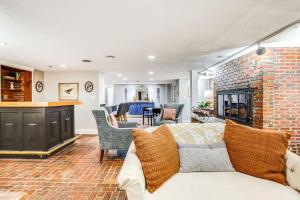 a living room with a couch and a brick fireplace at Chic Derby Square Condo in the Heart of Salem! in Salem
