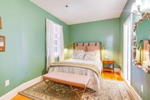 a bedroom with green walls and a bed with a bench at Chic Derby Square Condo in the Heart of Salem! in Salem