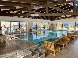 a large swimming pool with chairs in a house at Cumbalıca Beach Hotel in Çeşme