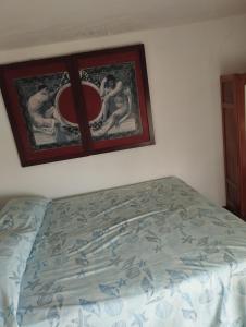 - une chambre avec un lit et deux photos sur le mur dans l'établissement Ischia forio monolocale arredato, à Ischia