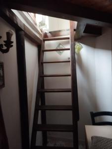une échelle menant à une chambre avec un mur blanc dans l'établissement Ischia forio monolocale arredato, à Ischia
