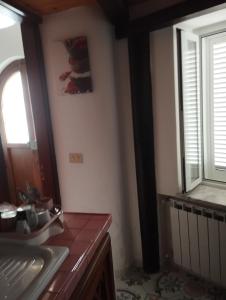 - une cuisine avec évier et une fenêtre dans la chambre dans l'établissement Ischia forio monolocale arredato, à Ischia