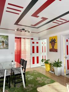 uma sala de jantar com tectos vermelhos e brancos em Westfield Gardens Apartment - 3 bedrooms em Goodmayes