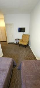 a room with two beds and a couch and a television at Ünver Hotel in Adana