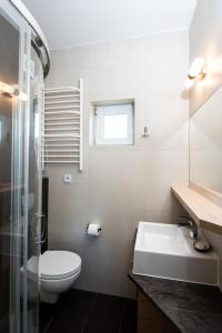 bagno bianco con servizi igienici e lavandino di Słoneczna Rafa - domki, pokoje i apartamenty a Sarbinowo