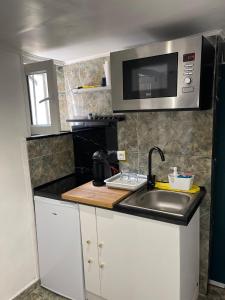 a small kitchen with a sink and a microwave at Studio fonctionnel & central proche paris in Villeneuve-Saint-Georges