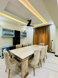 Luxurious kashmir house near Islamabad airport في Dhok Sandemār: غرفة طعام مع طاولة وكراسي خشبية