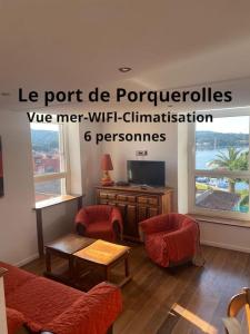 un soggiorno con sedie rosse e TV di Ile de Porquerolles : T3 climatisé vue mer a Porquerolles