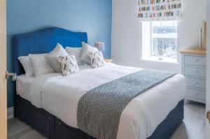 米爾福港的住宿－Harbour Heights - 2 Bed Apartment - Milford Haven，一间卧室设有一张蓝色墙壁的大床
