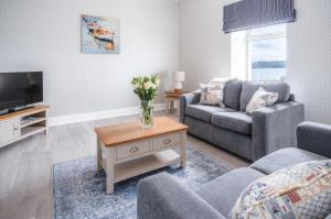 a living room with a couch and a tv at Beach Haven Hideout - 2 Bedroom - Milford Haven in Milford Haven