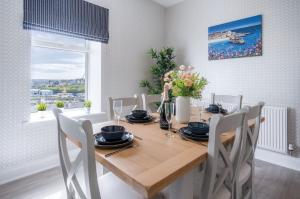 a dining room with a wooden table and chairs at Beach Haven Hideout - 2 Bedroom - Milford Haven in Milford Haven