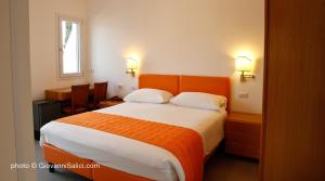 ein Schlafzimmer mit einem großen Bett mit einem orangefarbenen Kopfteil in der Unterkunft Garden Rooms 2 in Menaggio