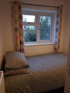 a bedroom with a bed and a window at Home in Kington St Michael in Stanton Saint Quintin