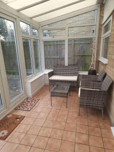 a screened in porch with chairs and a table at Home in Kington St Michael in Stanton Saint Quintin