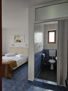 a bedroom with a bed and a bathroom with a toilet at Villa Mugur in 2 Mai