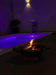 um quarto escuro com uma fogueira em frente a uma piscina em Shekinah em Sumaré