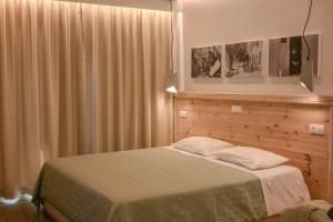 1 dormitorio con 1 cama y una ventana con cortinas en Patras Apartments, en Fourni Ikarias