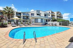 a swimming pool in front of a house at Scarborough Beach Front Resort - Shell Seven in Perth