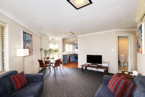 a living room with a blue couch and a television at Scarborough Beach Front Resort - Shell Seven in Perth