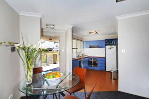 a kitchen with a glass table with a bowl of fruit at Scarborough Beach Front Resort - Shell Seven in Perth