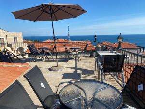 a patio with tables and chairs and an umbrella at Apartments Gusar in Ulcinj