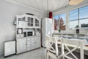 a kitchen with a table and a refrigerator at Rügenferienhaus eg und og in Schaprode