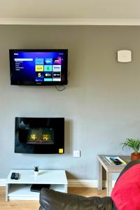 een woonkamer met een flatscreen-tv aan de muur bij Rum in Oban