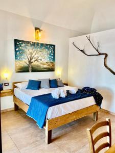a bedroom with a bed with a painting on the wall at Alencio Comfort Urbano in Favignana