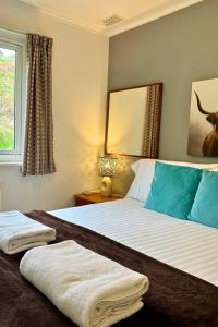 een slaapkamer met een bed met twee handdoeken erop bij Rum in Oban