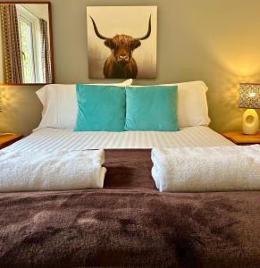 a bedroom with a bed with a bull painting on the wall at Rum in Oban +6 photos