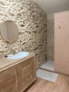 ein Badezimmer mit einem Waschbecken und einer Steinmauer in der Unterkunft Premier étage d une jolie maison à la campagne in Montravers