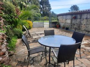 uma mesa e cadeiras sentadas num pátio em Casa Rural Cabo de Aráns em Oroso